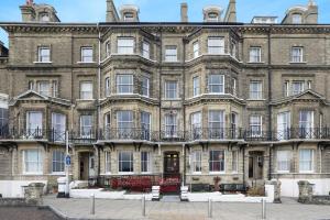 a large brick building with balconies on it at Lord Kitcheners Guest House in Lowestoft