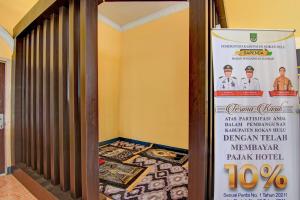 a sign for a restaurant with a poster of two chefs at OYO 92497 Penginapan Pasir Indah SyariahNearMonument Park City Sand Pengaraian in Pasirpengarayan