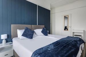 a bedroom with a large bed with blue walls at Lord Kitcheners Guest House in Lowestoft