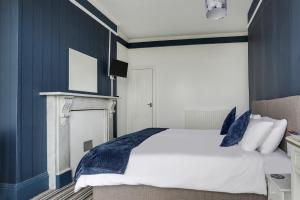 a bedroom with a large bed with blue walls at Lord Kitcheners Guest House in Lowestoft