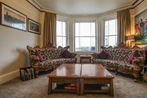 a living room with couches and a coffee table at Lord Kitcheners Guest House in Lowestoft