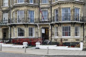 a building with an american flag in front of it at Lord Kitcheners Guest House in Lowestoft