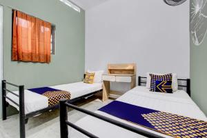 a room with two beds and a window at SPOT ON 92490 Casa Homestay Syariah in Brangsong