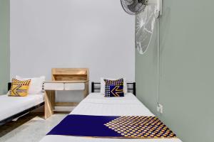a room with two beds in a room with a desk at SPOT ON 92490 Casa Homestay Syariah in Brangsong