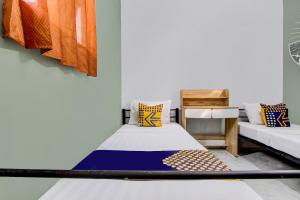a room with two beds with colorful pillows at SPOT ON 92490 Casa Homestay Syariah in Brangsong