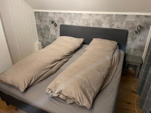 a bed with two pillows on it in a bedroom at Lars sitt hus in Lillehammer