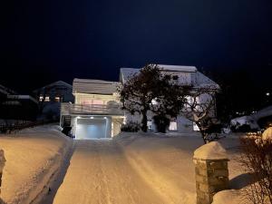a house is covered in snow at night at Lars sitt hus in Lillehammer