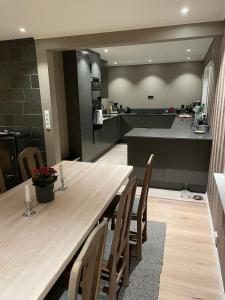 a kitchen and dining room with a wooden table and chairs at Lars sitt hus in Lillehammer