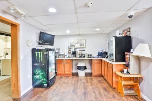 a kitchen with wooden cabinets and a refrigerator at OYO Hotel Pipestone MN, Canterbury Park in Pipestone
