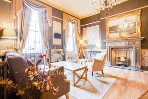 a living room with a fireplace and a table at Somerset Hotel Baker Street London in London