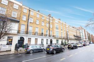 a row of cars parked in front of a large building at Somerset Hotel Baker Street London in London