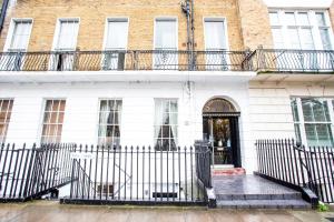 a white building with a gate and a door at Somerset Hotel Baker Street London in London
