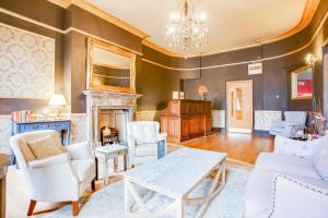 a living room with a table and chairs and a fireplace at Somerset Hotel Baker Street London in London