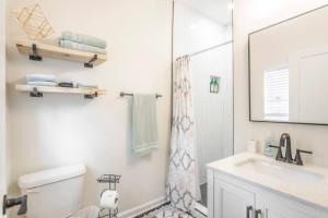 a bathroom with a toilet and a sink and a mirror at The Arches Walk To Western Ave District in Oklahoma City +15 photos