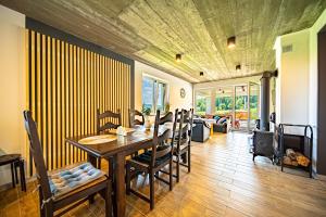 a dining room with a wooden table and chairs at Domki Pod Chełmem in Brunary Niżne