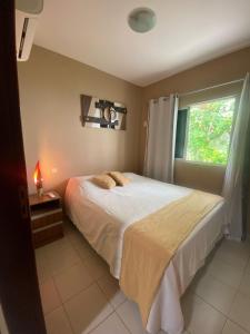 a bedroom with a large bed and a window at Casa Paraiso Beira-Mar in Maracajaú