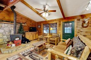 a living room with a fireplace in a log cabin at Moose Creek Lodge in Sylva