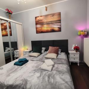 een slaapkamer met een groot bed met kussens erop bij Współczesny Apartament Gdańsk in Borkowo +24 foto's