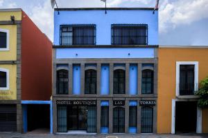a building with blue paint on the side of it at Capital O Hotel Boutique Las Torres in Tlaxcala de Xicohténcatl