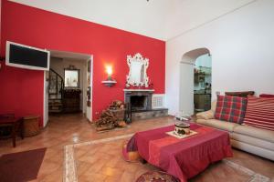 a living room with red walls and a couch and a table at Casale il tramonto in Massa Lubrense