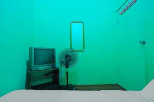 Cette chambre comprend un lit, un ventilateur et une télévision. dans l'établissement Hotel O Joyoakis Homestay SyariahNearMall Nagoya Hill, à Nagoya