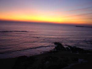 a sunset over the ocean with a pier in the distance at Atlantic Hôtel & Spa in Les Sables-d'Olonne