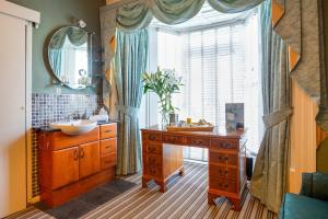 a bathroom with a wooden dresser and a sink and a window at OYO Lamphey Hall Hotel in Pembroke +22 photos
