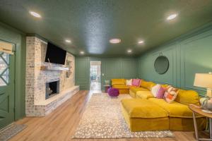 俄克拉何马城Luxury 4BR OKC Retreat w Hot Tub & Pool Table的客厅设有黄色的沙发和壁炉