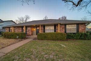 俄克拉何马城Luxury 4BR OKC Retreat w Hot Tub & Pool Table的前面有灌木丛的砖房