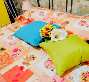 a bed with flowers and pillows on it at Villa Sant Anna in Alghero
