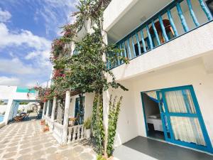 a house with blue doors and a tree in front of it at Pousada La Grécia in Camocim