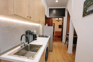 een keuken met een spoelbak en een koelkast bij Rezis sweet home in Tbilisi City +3 foto's