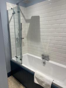 a bathroom with a bath tub with a glass shower at Contemporary apartment in Cromer in Cromer +16 photos