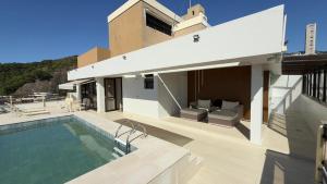 a villa with a swimming pool and a house at Flat Leblon inn in Rio de Janeiro +4 photos