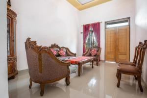 - un salon avec des chaises, un canapé et une fenêtre dans l'établissement Hotel O Homestay Romauli Kampung Radja, à Jambi