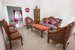 - un salon avec plusieurs chaises et un canapé dans l'établissement Hotel O Homestay Romauli Kampung Radja, à Jambi