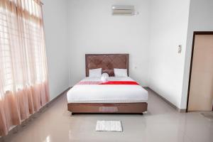 une chambre avec un lit dans une pièce blanche dans l'établissement Hotel O Homestay Romauli Kampung Radja, à Jambi 17 autres photos