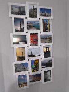eine Wand mit Fotografien an einer weißen Wand in der Unterkunft El Piso de Montse in A Coruña