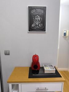 einen Tisch mit einer roten Teekanne darüber in der Unterkunft El Piso de Montse in A Coruña