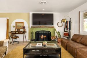a living room with a couch and a fireplace at Tranquil Gardens Soaking Pool Ember Stone in Yucca Valley +29 photos