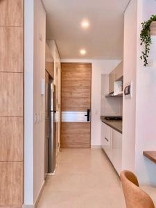 a hallway leading to a kitchen with a wooden door at Apartamento Frente al Mar D Lujo 901- Santa Marta in Playa Bello Horizonte