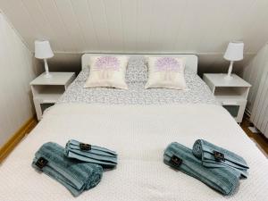 a bedroom with a bed with two pillows and towels at Domek Natura Rybno in Rybno +30 photos