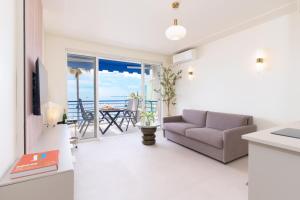 a living room with a couch and a view of the ocean at Studio terrasse vue mer idyllique in Antibes