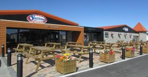 a group of picnic tables in front of a restaurant at Caravan - 3 Bedrooms, Sleeps 8 in Rhyl