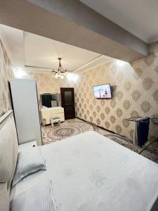 a bedroom with a bed and a tv on the wall at Apartment 3 in Dushanbe