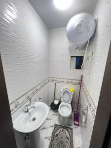 a white bathroom with a sink and a toilet at Apartment 3 in Dushanbe