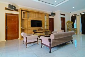 a living room with chairs and a flat screen tv at Collection O 92634 Villa Ds in Sumedang