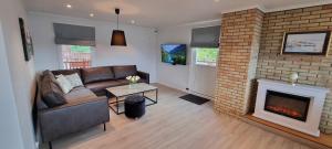 a living room with a couch and a fireplace at Apartment- fjord view, big terrace, close to Moa in Ålesund