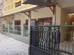 a building with a wrought iron gate on a street at OYO Life 92620 Syfa Kost in Malang