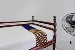 Hotel O Umi Homestay Syariah في سيدوارجو: سرير مع مروحة تجلس بجانبه +20 صورة